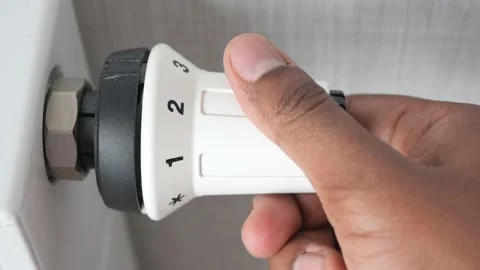 Hand adjusting temperature on heating radiator Video stock 237476451