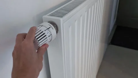 Hand adjusting temperature on the heating radiator for home heating Stock Footage 288467658