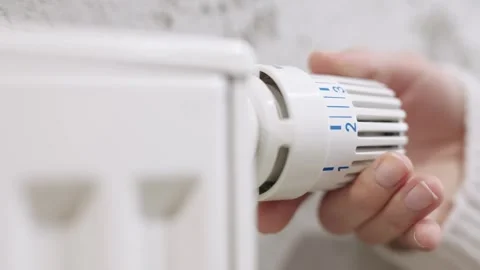 A hand adjusting the temperature on a radiator Stock Footage 295883421
