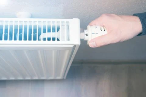 Hand adjusting temperature on radiator Stock Photos