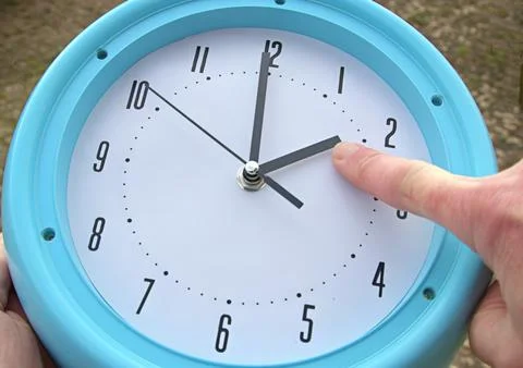 Hand adjusting the time on a clock Stock Photos