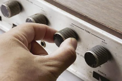 Hand is adjusting tone volume button Foto stock