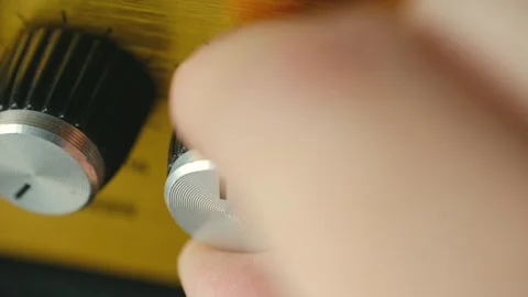 Hand adjusting volume knob on amplifier Stock Footage 318918284