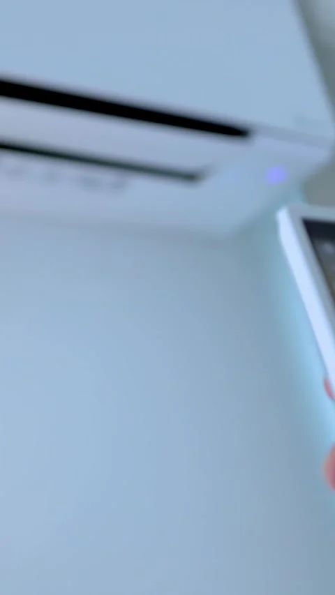 Hand Adjusting Wall Mounted Air Conditioner Temperature With Remote Control Stock Footage 337758012