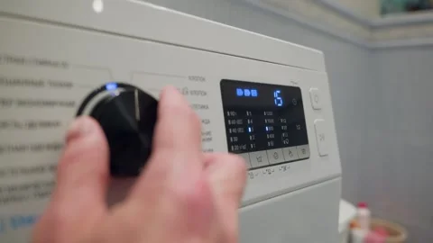 Hand adjusting washing machine dial, closeup operation with controls Stock Footage 341559302