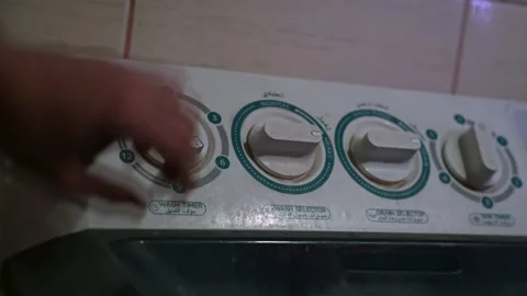 Hand Adjusting Washing Machine Timer in Low Light – Realistic Domestic Close-Up Stock Footage 313597266