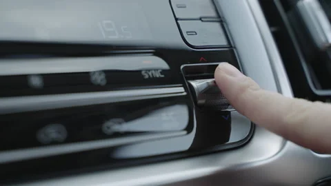 Hand adjusts the air conditioner control buttons in the car. The climate control Stock Footage 150088020
