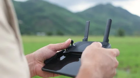 A hand adjusts the antenna on a quadcopter remote control. Stock Footage 321727885