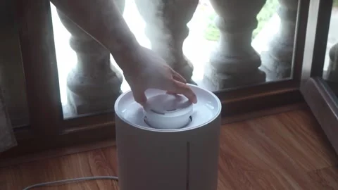 Hand adjusts humidifier direction on dry, summer's day Stock Footage 314719828