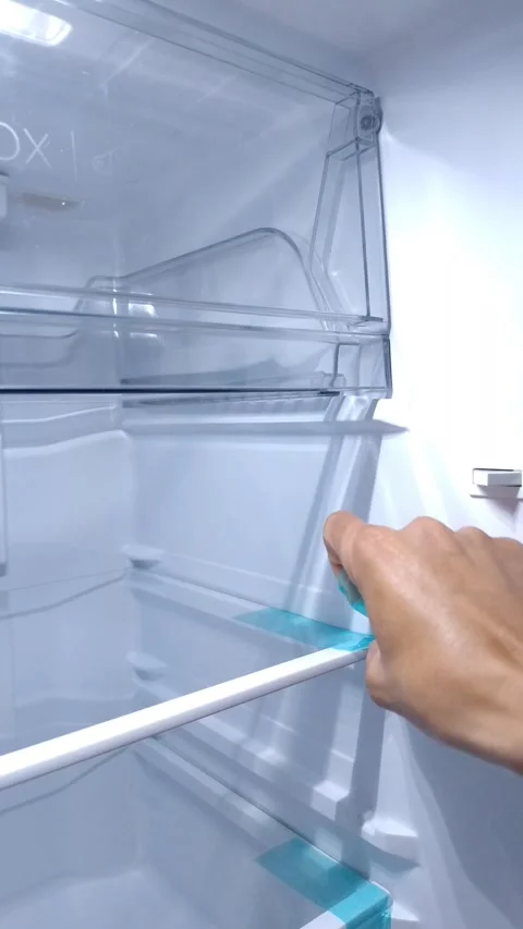 Hand adjusts a refrigerator shelf Stock Footage 332259835
