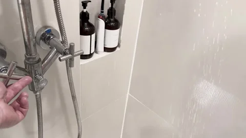Hand Adjusts Shower Controls and Tests Water Flow in Bathroom Stock Footage 320031982