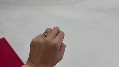 Hand adorned with big oval diamond ring above smooth ice surface Stock Footage 320015247