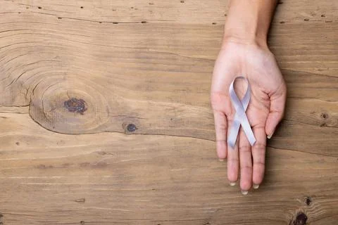 Hand of african american mid adult woman with white lung cancer awareness ribbon Stock Photos
