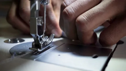 Hand of afro-american seamstress using a white industrial sewing machine Vidéo 132235692