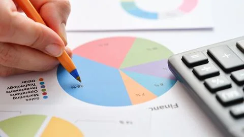 A hand analyzing a financial report 库存照片
