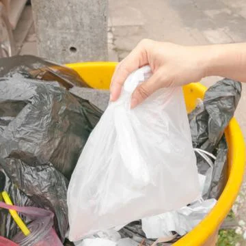 Hand and full trash bin Stock Photos