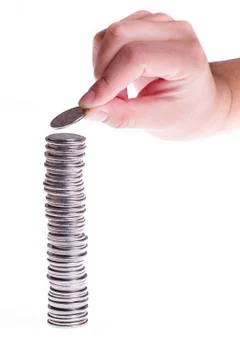 Hand and high stack of coins Foto stock