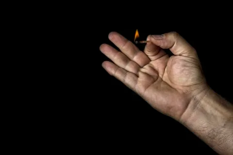 Hand and match on black background Stock Photos