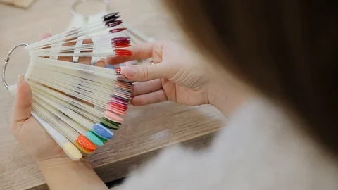 Hand and nail design samples. Woman in nail salon choosing design. Selection of Stock Footage 129458673