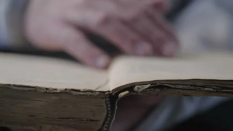 Hand and old book. A man's hand holds a book and read. Video is looped. Vídeos de archivo 106031398