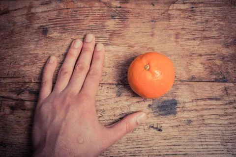 Hand and orange on table Fotos Stock