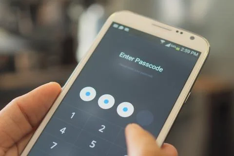 Hand and smartphone with password code in screen Stock Photos