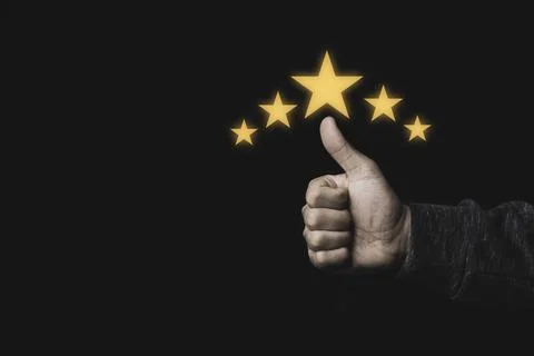 Hand and thumb rise up with five yellow stars on black background Stock Photos