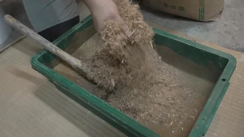 Hand and Wooden Tool Working Wet Earth in a Tray Stock Footage 340900988