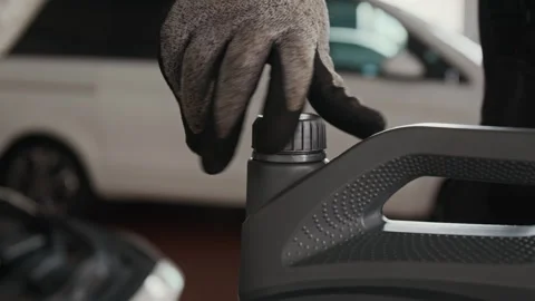 Hand of Anonymous Mechanic Removing Cap from Canister to Replace Engine Oil Stock Footage 329405137