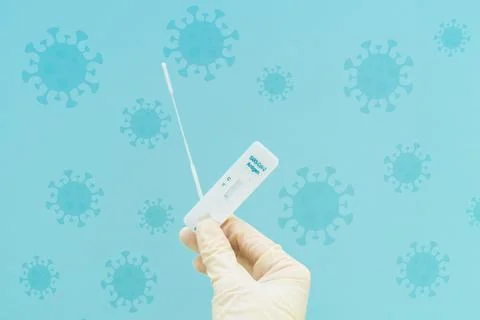 Hand with antigen test on blue background with virus. Concept pandemic covid Stock Photos