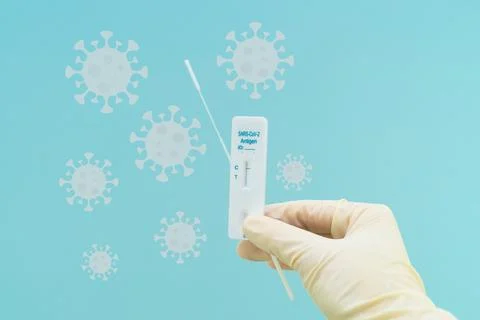 Hand with antigen test on blue background with virus. Concept pandemic covid Stock Photos