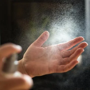 Hand antiseptic spray in usage Stock Photos