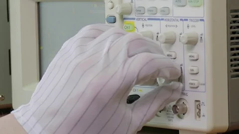 Hand in antistatic glove adjusting parameters of modern oscilloscope Stock Footage 76626912