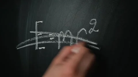 A hand appears on a chalkboard, initially writing the equation Emc, then Stock Footage 338186456