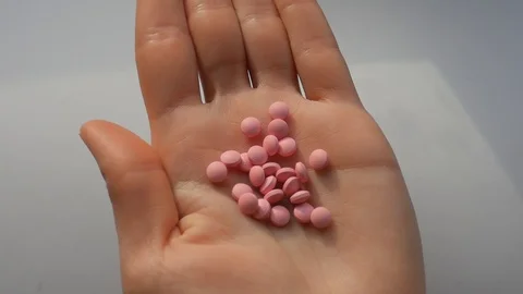Hand appears in the frame. Hand opens, showing pills in his palm. Stock Footage 124632249