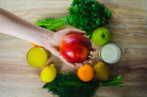 In the hand of the Apple on a background of vegetables Stock Photos