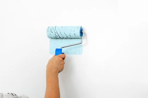 Hand Applying Blue Paint On Interior Wall Using Paint Roller Stock Photos