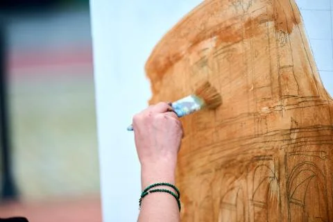 Hand applying brown paint on architectural sketch in natural light Foto stock