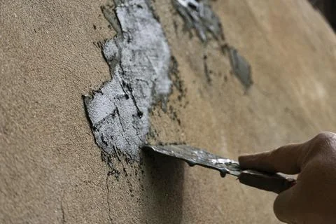 Hand Applying Cement with Trowel on Wall Stockfoto's
