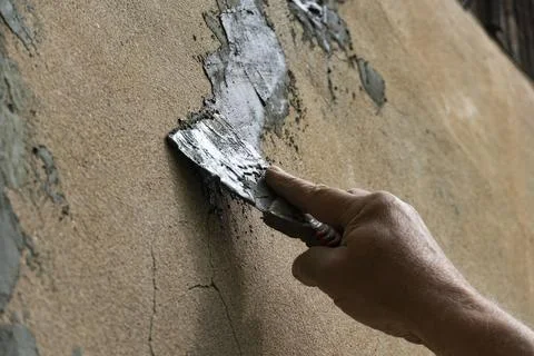 Hand Applying Cement with Trowel on Wall Stock Photos