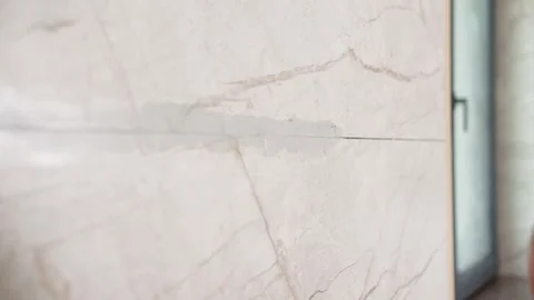 Hand applying grout between marble tiles with trowel Stock Footage 340458175