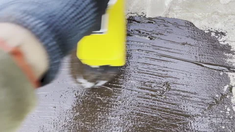 Hand Applying Liquid Waterproofing Membrane with Large Brush – Construction Work Stock Footage 316643742