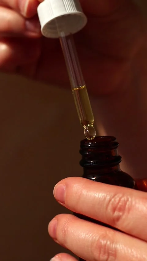 Hand applying plant based oil with precision dropper. Perfect for vegan skin Stock Footage 310606103