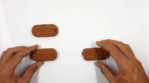 Hand arranging brown cookies sequentially in motion video Stock Footage 330165381