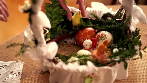 Hand arranging easter basket brought to church to be blessed on Holy Saturday Stock Footage 103837332