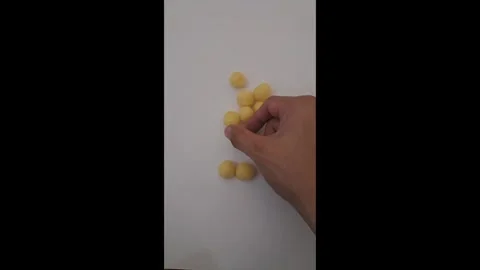 Hand Arranging Golden Crispy Cheese Ball Puffs Snack on White Table Видео 337788269