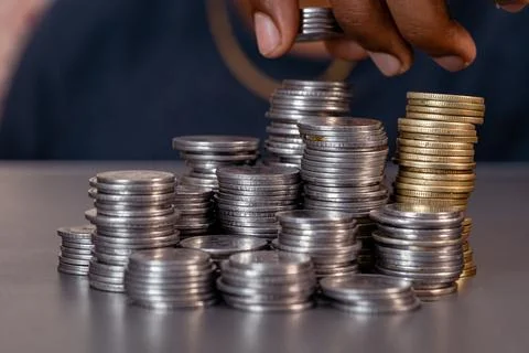 Hand Arranging Stack of Coins Stock Photos