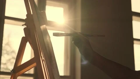 Hand with artist's brush in front of sunlight Stock Footage 158048073