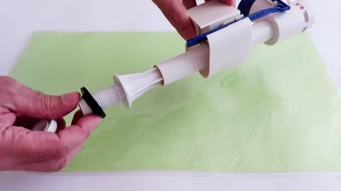 Hand Assembles Toilet Flush Valve on Green Mat-Clean, Precise Motion Stock Footage 314638248