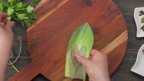 Hand assembling bouquet garni top view with herbs and spices Stock Footage 309765830